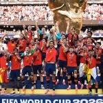 The Spain national football team celebrating on the podium as official FIFA World Cup 2026 Champions with Rodri lifting the trophy.